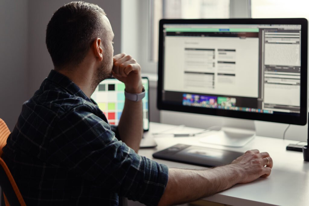Handsome freelancer man working remotely from home. Young male working on his computer