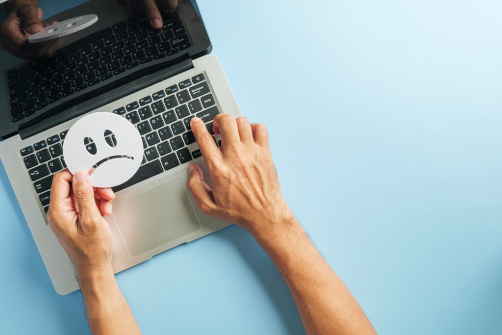 Customer review for laptop shows sad face, reflecting negative feedback, client dissatisfaction online, poor survey results, monitoring brand reputation, voice of customer indicates bad experience.