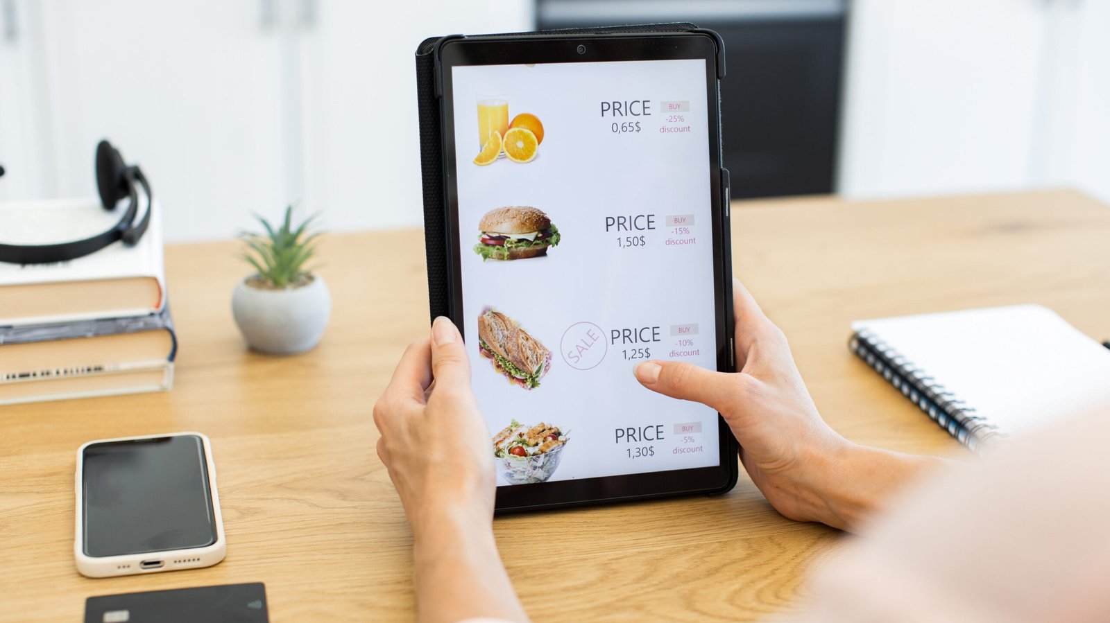 Caucasian woman using a digital tablet to order food online from delivery app. Scene depicts modern technology, digital payments, and convenience of online shopping.