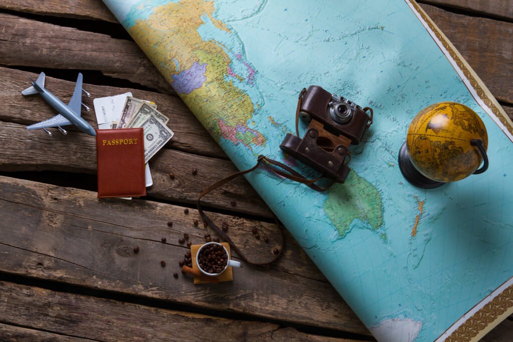 Passport and big map. Globe near vintage camera. Choose any place on map. You can travel freely.